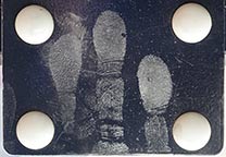 Fingerabdrücke auf einer Türdrückerplatte, eingestäubt mit Fingerabdruckpulver Konzentriertes Silber