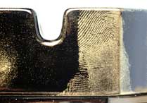 Fingerprint developed with Instant Gold on black ashtray